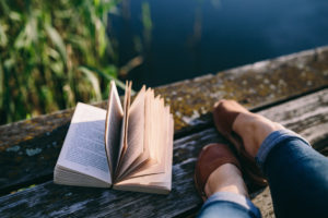 kaboompics-com_girl-and-opened-book-on-old-wooden-pier